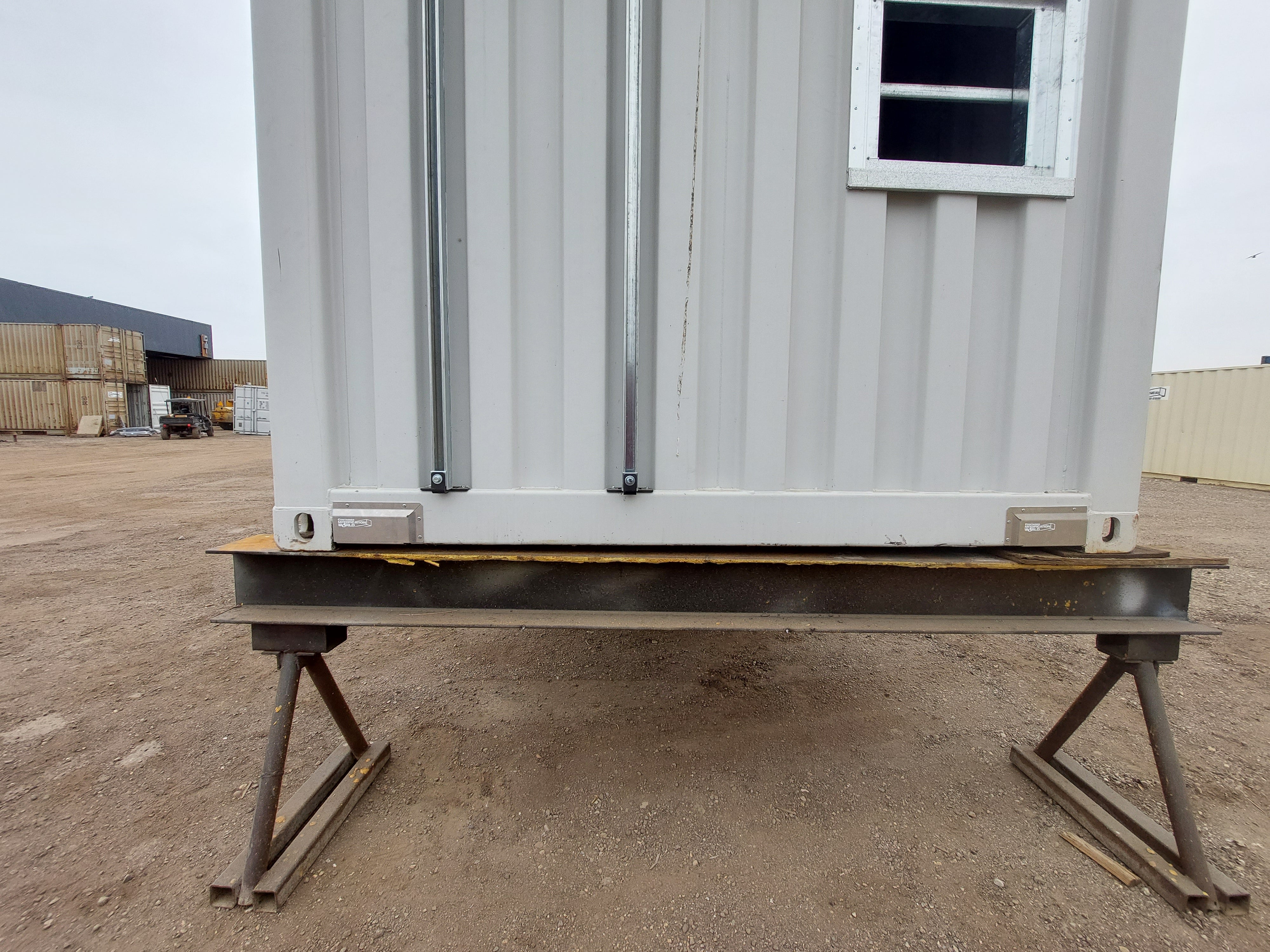 Installed fork pocket covers on the underside of a shipping container, securely blocking forklift holes to contain spray foam insulation