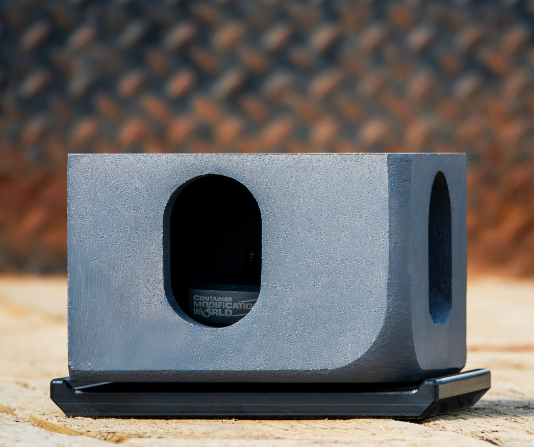 Black HDPE container shoe installed beneath an ISO corner casting, demonstrating fit and surface protection for shipping container placement